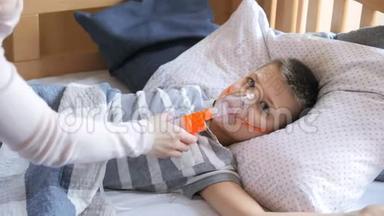 小男孩被用雾化器治疗，咳嗽。 小男孩使用雾化器进行吸入治疗
